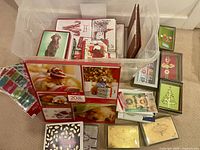 Clear bin with numerous boxed Christmas cards and window gel cling visible