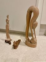 All four wooden carvings grouped on carpet