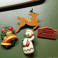 Front view of four Christmas brooch pins