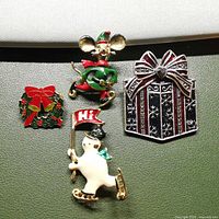 Four Christmas themed brooches laid out