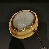 Top view of Eveready cream wall sconce with white diffuser and pull chain