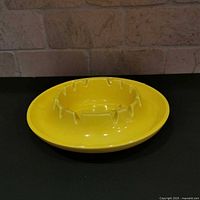 Top view of yellow ceramic ashtray showing cigarette rests and interior