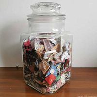 Front view of glass jar showing contents of fabric scraps and buttons