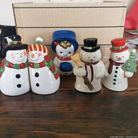 All five ceramic snowman shakers on table