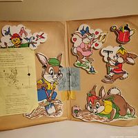 Interior view of unopened pin-up sheet with six die-cut rabbits, watering can and scarecrow plus instruction sheet