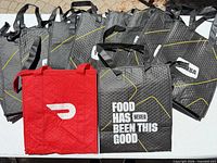 Group of Yumba and DoorDash insulated delivery bags displayed on table