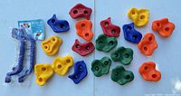 All 18 colourful climbing holds, two blue handles in packaging, instruction sheet