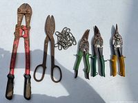 Full set laid out: bolt cutters, tinner’s snips, three aviation snips, quick links