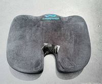 Front view of Everlasting Comfort seat cushion showing logo, ergonomic cutout and taped repair