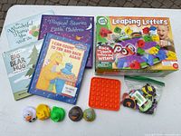Overview of all items: books, LeapFrog game, pop-it, ducks, alphabet pieces