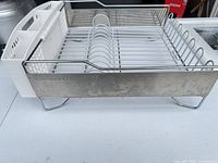 Side view showing stainless panel, wire feet, plastic end with utensil holder