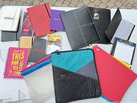 Top view of all notebooks, binders, folios, clipboard, sleeves and labels laid out