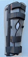 Side view showing gray exterior shell, black Velcro straps, side cut-out and D-rings