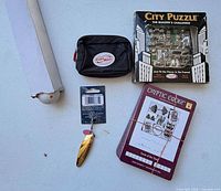 All five items laid out: City Puzzle box, Cryptic Code cards, FuelBelt pouch, Sea Striker lure, ball in sleeve