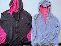 Black and grey Puma hoodies side by side