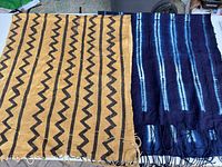 Both cloths side by side showing overall designs, colors and fringes
