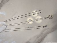 Three sterling silver chains displayed side by side, two with pendants visible