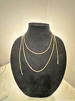 Three gold-filled chain necklaces displayed on bust