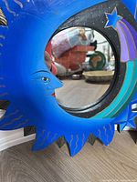 Front view of painted wood celestial mirror with blue crescent moon, shooting star motif and central glass