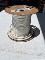 Side view of entire spool showing cable wound and rust on top flange