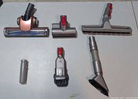 All six Dyson attachments arranged on table surface