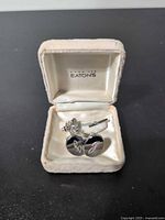 Open Eaton's box displaying cufflinks, tie clip, tie tack