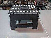 Step stool unfolded, front view showing white grip squares