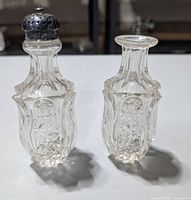 Pair of lead crystal shakers, one with lid, one without