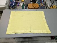 Full view of pale yellow waffle knit baby blanket laid flat