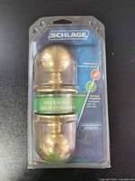 Front view sealed Schlage brass passage knob set in clamshell