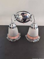 Front view of chrome two-light wall sconce with both frosted shades attached