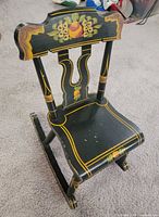 Front three-quarter view of child rocking chair showing painted decoration and form