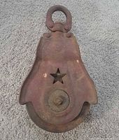 Front view of cast iron Starline barn pulley showing star cutout and swivel eye