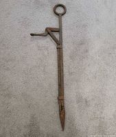 Full view of hay bale spear showing ring handle, hook arm and spear tip