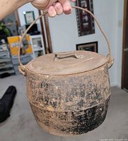 Side view of cauldron with lid and handle