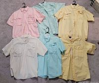 All six fishing shirts laid flat showing fronts