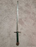 Full view of metal sword on carpet