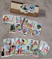 Box with large stack of loose football cards spread on floor