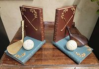 Front view of both golf-themed resin bookends on wood surface
