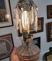 Front view of glass lamp lit, showing prisms and patterned base