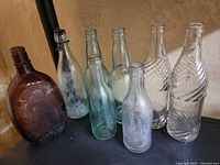 Group shot of all eight vintage glass bottles on shelf