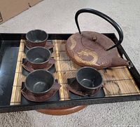 Full set showing teapot, cups, saucers, tray, bamboo mat