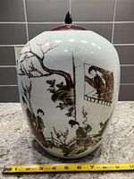 Front view showing painted figures, tree, inset portrait, measuring tape for scale