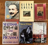 All six biography books arranged on floor