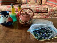 Group shot showing vase, teapot, two cruets, bag of marbles/stones