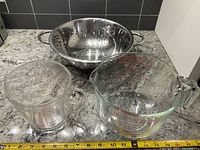 Two Pyrex measuring cups and stainless colander