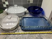 Group shot showing both casseroles, baking dish with carrier, blue bowl