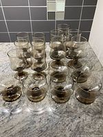 Front overhead view of all 17 smoke-coloured stem glasses grouped together