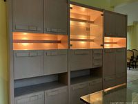 front view showing full three-section wall unit with lights on