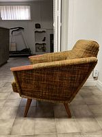 Side view of MCM arm chair showing teak armrest, upholstery, legs